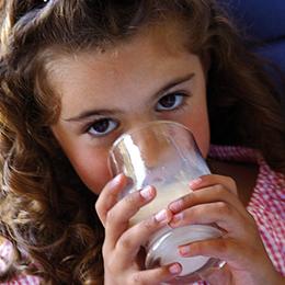 Petite fille qui boit un verre de lait