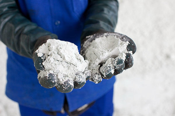 Mains gantées de noir montrant de la pâte à papier brute